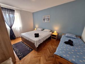sypialnia z 2 łóżkami i oknem w obiekcie Apartmani Eškinja w Biogradzie na Moru