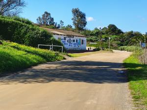 a dirt road with a house in the distance at Kingfisher by the river - self catering in Velddrif