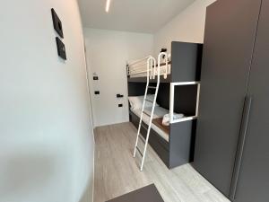 ein kleines Zimmer mit einem Etagenbett und einer Leiter in der Unterkunft The Twins 2 Luxury Home - Lungomare Viale Milano 20 in Riccione