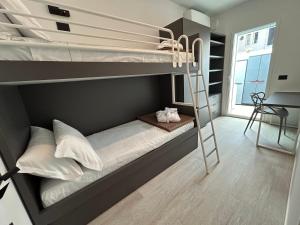 sypialnia z 2 łóżkami piętrowymi i drabiną w obiekcie The Twins 2 Luxury Home - Lungomare Viale Milano 20 w mieście Riccione