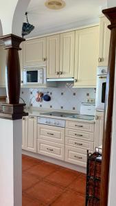 eine Küche mit weißen Schränken und weißen Geräten in der Unterkunft Precioso Duplex en Sanxenxo a 400m de las playas in Sanxenxo + 15 Fotos