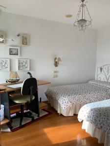 ein Schlafzimmer mit zwei Betten und einem Schreibtisch und einem Stuhl in der Unterkunft Precioso Duplex en Sanxenxo a 400m de las playas in Sanxenxo