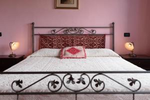 a bedroom with a bed with a red pillow and two lamps at Tenuta Don Ballore in Galtellì