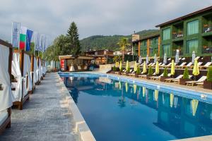 a swimming pool with lounge chairs and a hotel at Мия 2 Deluxe Royal Spa in Velingrad