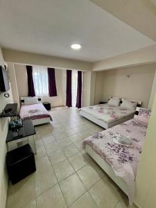 a hotel room with two beds and a television at Lux Ohrid in Ohrid