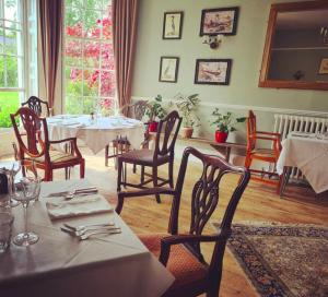 Farthings Country House Hotel & Restaurant Tunton في تونتون: غرفة طعام مع طاولات وكراسي