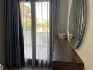 Habitación con ventana con cortinas y mesa de madera. en Αura Luxury Apartments, en Ierissos