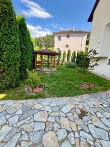 a stone patio with a gazebo in a yard at Lux Ohrid in Ohrid