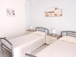 2 Betten in einem Zimmer mit weißen Wänden in der Unterkunft Vacanze Sicilia in Trappeto