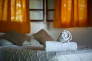 Una toalla enrollada encima de una cama en Inti Wasi en San Carlos