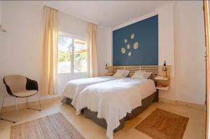 ein Schlafzimmer mit einem großen weißen Bett und einem Stuhl in der Unterkunft Luxury 2 bedroom apartment, close to the sea and the golf course, Aloha Hills Club Property in Marbella + 34 Fotos