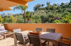 ein Esszimmer mit einem Tisch und Stühlen auf einer Terrasse in der Unterkunft Luxury 2 bedroom apartment, close to the sea and the golf course, Aloha Hills Club Property in Marbella