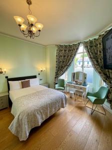 1 dormitorio con 1 cama, TV y ventana en Shandon Bells Guest House en Cork