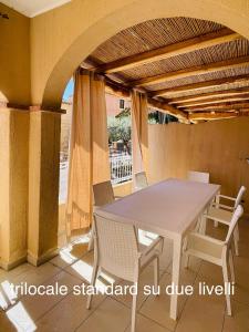 einen Tisch und Stühle auf einer Terrasse mit Sonnenschirm in der Unterkunft Appartamenti Shardana in Villasimius