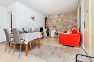 a dining room with a table and a red couch at Apartman Babich in Rovinj