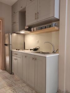 a kitchen with white cabinets and a sink and a refrigerator at Villa Chrisanthi in Parga +156 photos