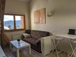 a living room with a couch and a table at Bonito y luminoso apartamento con wifi y chimenea Aizú - Villanúa in Villanúa