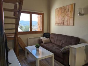 a living room with a couch and a table at Bonito y luminoso apartamento con wifi y chimenea Aizú - Villanúa in Villanúa