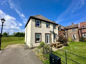 ein Haus mit einer Picknickbank davor in der Unterkunft Dragonfly Cottage in Filey