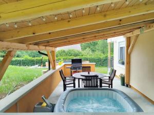 einen Whirlpool auf einer Terrasse mit einem Tisch und Stühlen in der Unterkunft Holiday House Provance in Brod na Kupi