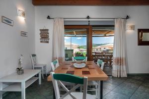 a dining room with a wooden table and chairs at Villetta a Cannigione in Cannigione +15 photos