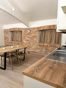 eine Küche mit einem Tisch und einer Ziegelwand in der Unterkunft Simona Apartments in Portocannone