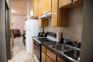 a kitchen with a sink and a refrigerator at Premium Inn and Suites in Killeen