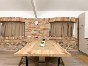 ein Esszimmer mit einem Holztisch und einer Ziegelwand in der Unterkunft Simona Apartments in Portocannone