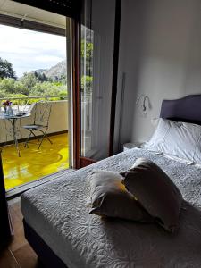 a bedroom with a bed and a view of a balcony at Vida Locrese con piscina salata in Gerace