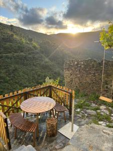 a table and chairs on a balcony with a view at White House in Piódão