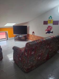 Consigliato monolocale في أنغري: غرفة معيشة مع أريكة وتلفزيون بشاشة مسطحة