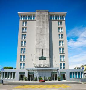 ブスト・アルシーツィオにあるTower Hotelのタワーホテルの看板が貼られたホテルの建物
