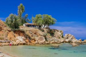 a house on a hill next to a body of water at My AVRA, flat in Agioi Apostoloi Chania in Daratso