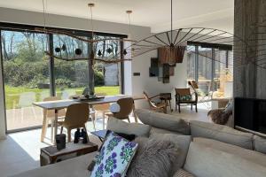 a living room with a couch and a table at Le lodge Cotentin - Maison de charme vue mer in Éculleville