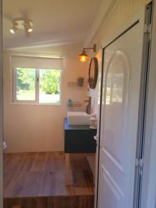 ein Badezimmer mit einem Waschbecken, einem Fenster und einer Tür in der Unterkunft Quinta da Maínha - Charming Houses in Braga