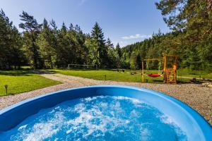 una bañera azul llena de agua junto a un parque infantil en Smerekowiec domek w lesie, en Smerekowiec