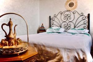 - une chambre avec un lit orné d'une tête de lit dans l'établissement Maison Zaitouna, à Marrakech