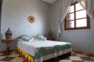 a bedroom with a bed and a window at Maison Zaitouna in Marrakech