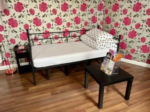 un banc dans une pièce avec un mur fleuri dans l'établissement Entire PinkApt - Free parking - Up to 4 guests - 3 beds - Close to city centre, à Belfast