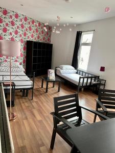 Cette chambre comprend 3 lits, une table et des chaises. dans l'établissement Entire PinkApt - Free parking - Up to 4 guests - 3 beds - Close to city centre, à Belfast