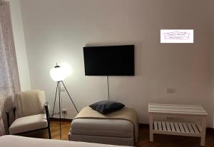 a living room with a couch and a tv on the wall at Casetta Mazzini in Rapallo