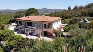 une vue aérienne sur une maison avec des montagnes en arrière-plan dans l'établissement Appartamenti Serenity - 2 posti auto - in villa e in centro, à Marina di Campo