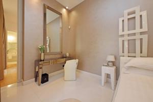a white bedroom with a sink and a mirror at Domus Aurea Luxury Suites in Rome
