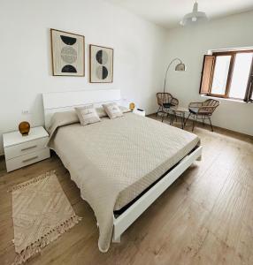 Un dormitorio blanco con una cama grande y una mesa en La Contra, en Porto Ottiolu