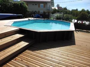 a large swimming pool on a wooden deck at Villa Cathy Studio Terrasse Léane in Aix-les-Bains