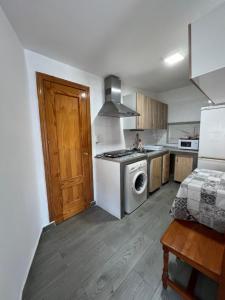 a kitchen with a stove and a washer at Casa Paula in Ceuta