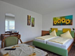 a bedroom with two beds and a table at Hotel Garni Hutter in Unterburg am Klopeiner See
