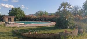 a swimming pool in a yard with a retaining wall at L'Oasi in Zagarolo