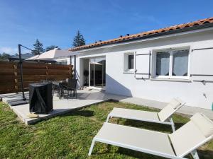 a white house with a patio and chairs at Maison au calme proche océan in Vielle-Saint-Girons