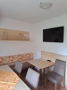 レオガングにあるApartment Haus Millauerのテーブルと椅子、薄型テレビが備わる客室です。